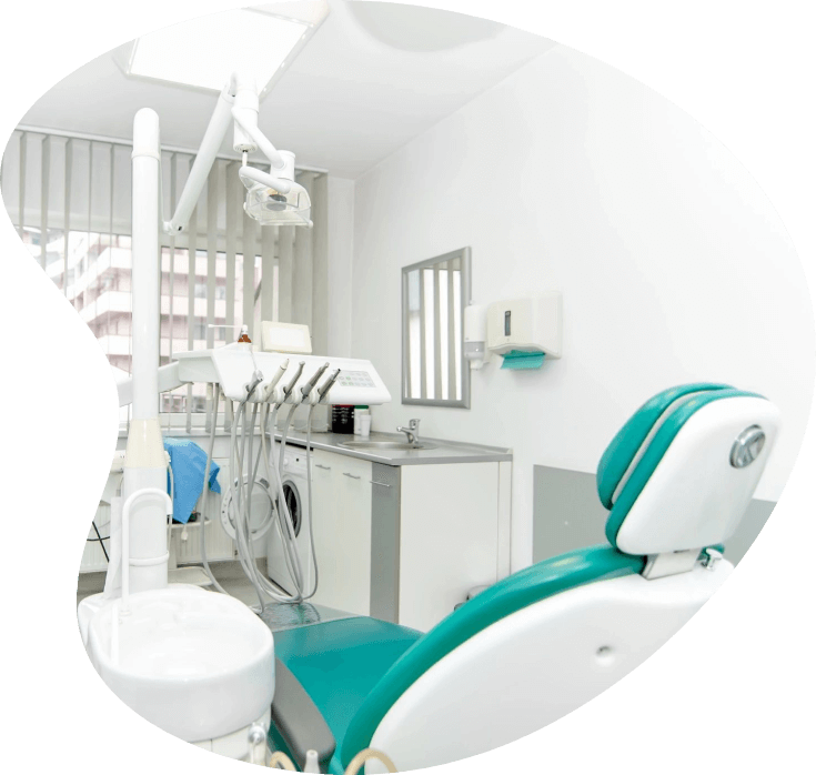 A dentist 's office with green chairs and white walls.
