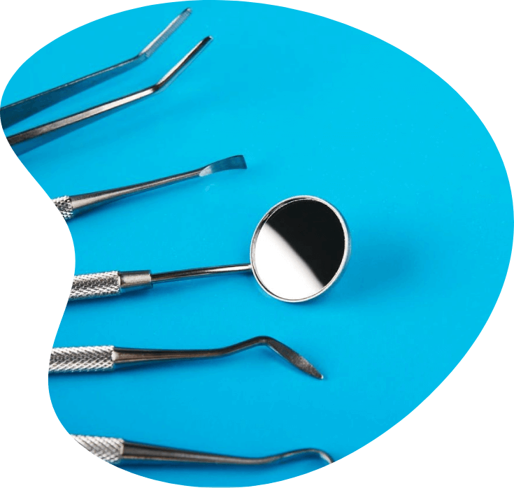 A group of dental instruments sitting on top of a blue surface.